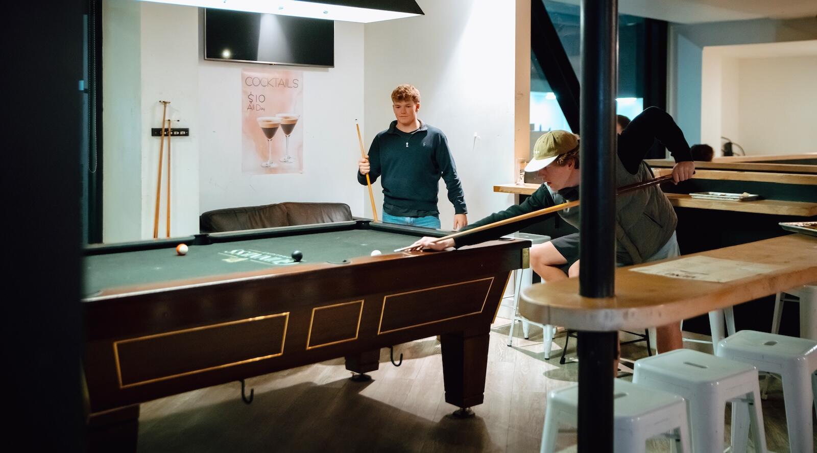 Two locals playing pool at Biddy Kate's Bar in Blenheim